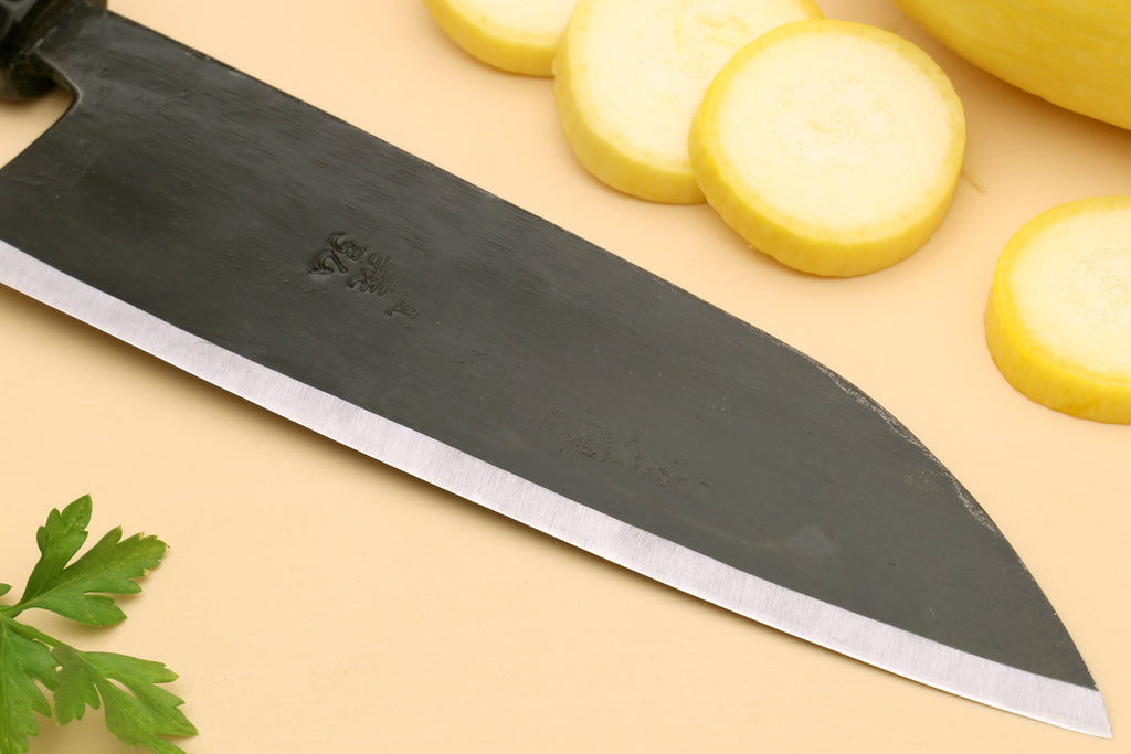 Santoku chef knife close-up of blade spine and edge, light steel bevel