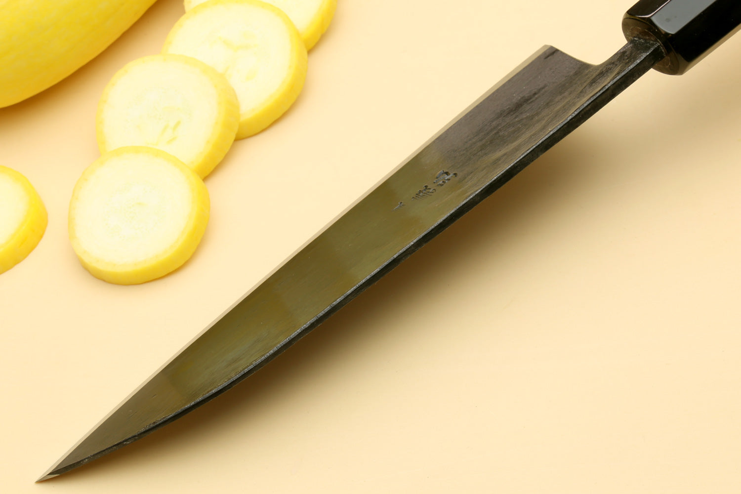Santoku chef knife tip view with dark blade and camphor handle