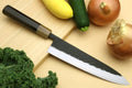Gyuto chef's knife with dark handle and black-speckled blade, stainless edge