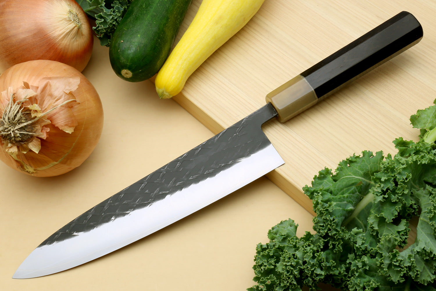 Gyuto chef's knife with dark handle and black-patterned blade, pointed tip