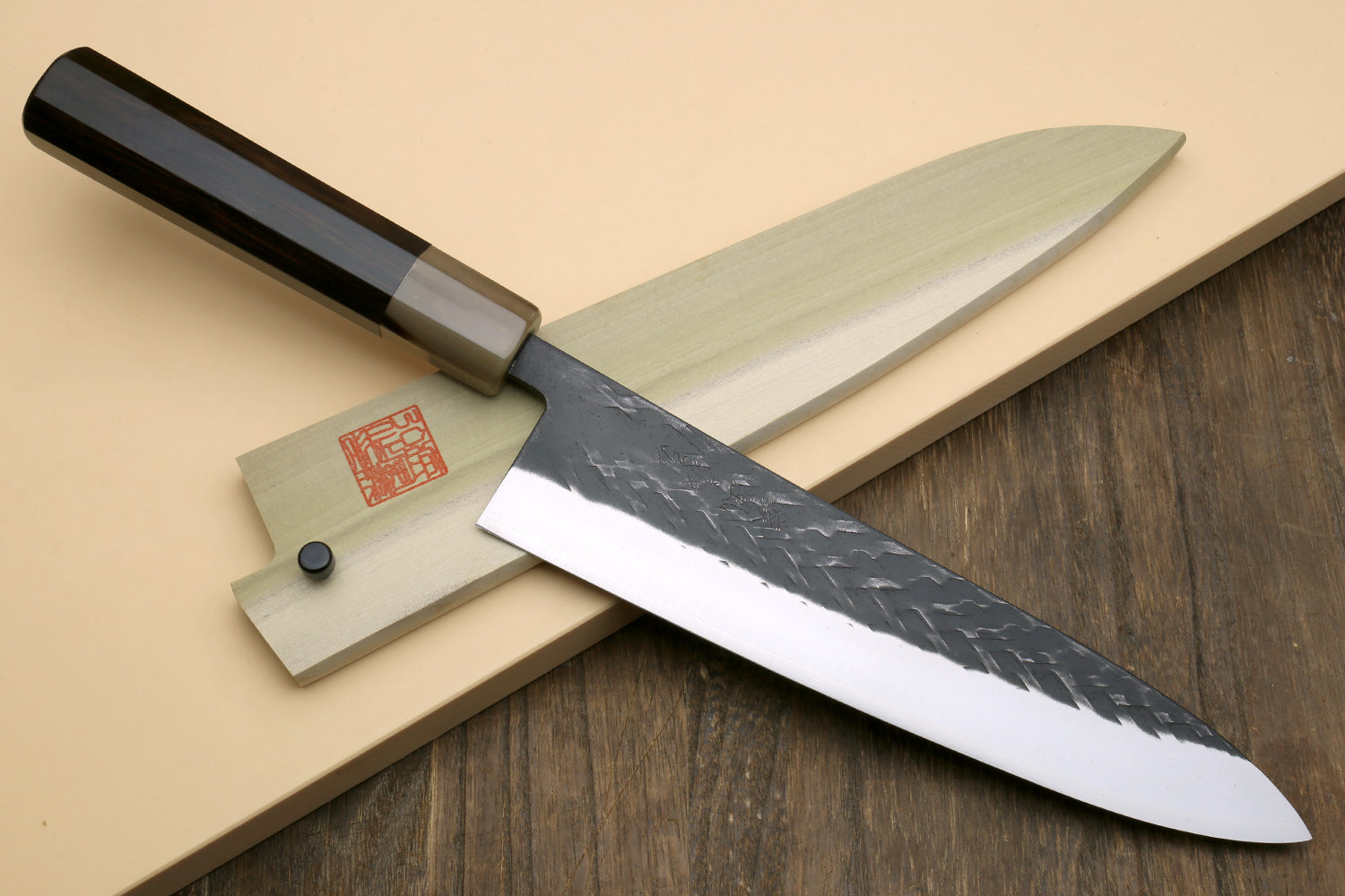 Gyuto-style chef knife with dark handle and speckled blade, plus a smaller accessory knife