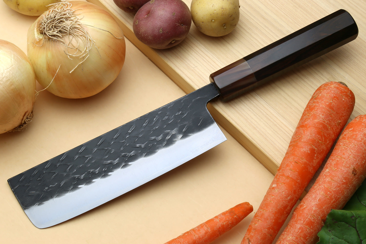 Nakiri vegetable knife with dark hammered blade and black handle, saya cover attached