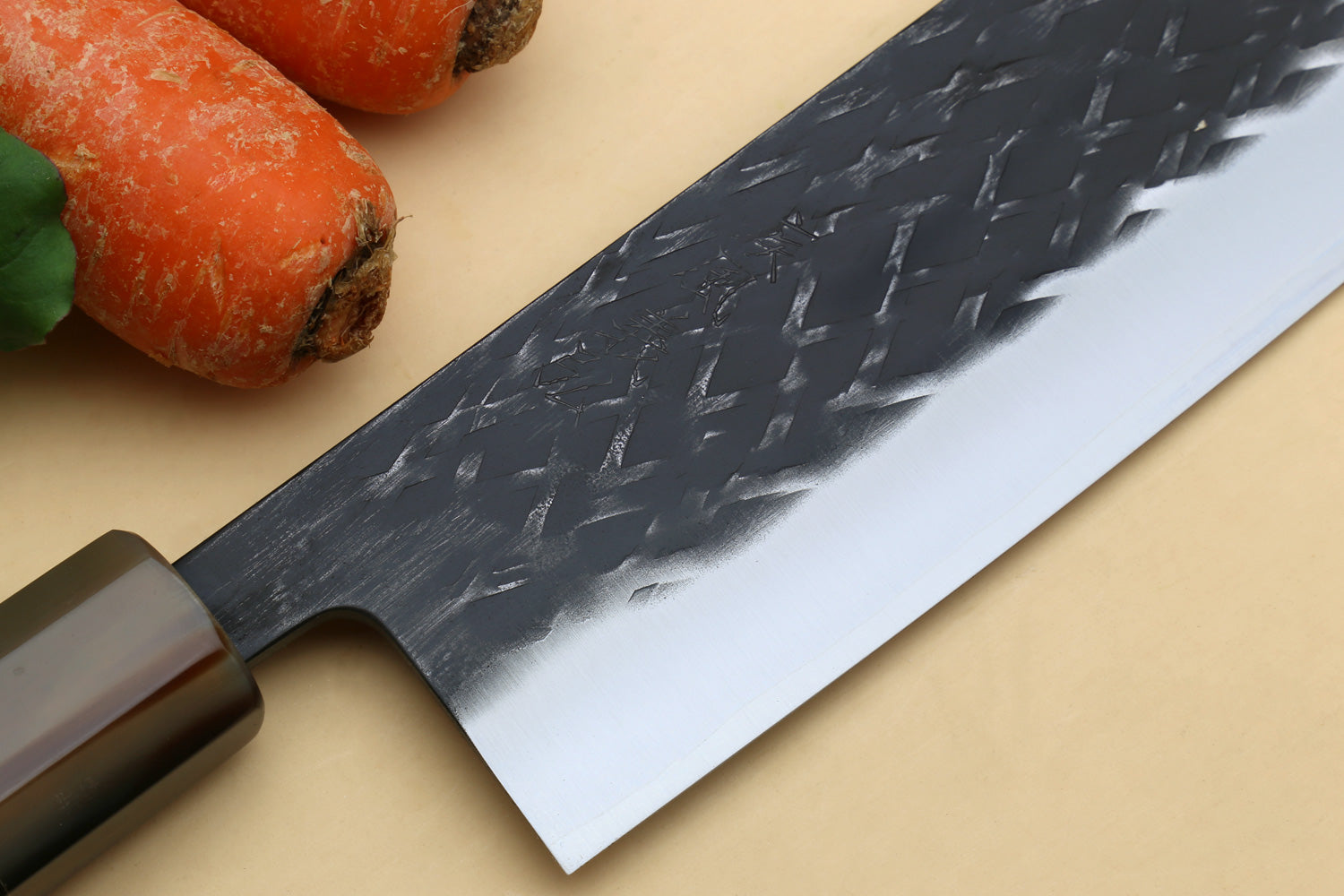 Nakiri vegetable knife blade close-up with dark hammered texture and white steel edge