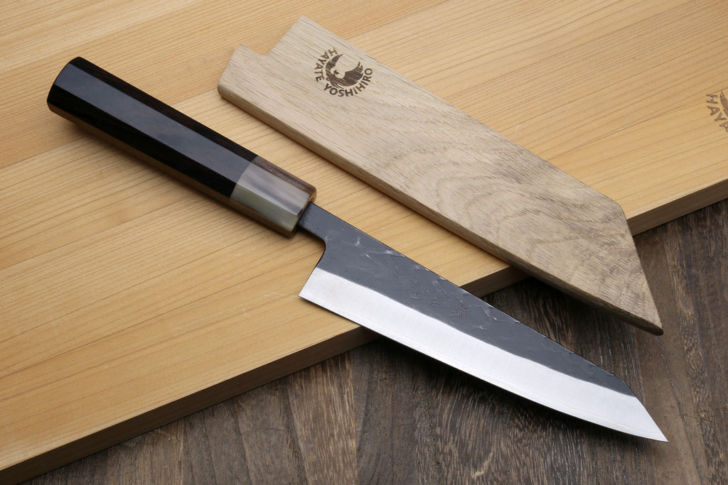 Petty-utility knife with dark handle and wooden saya cover, textured dark blade visible
