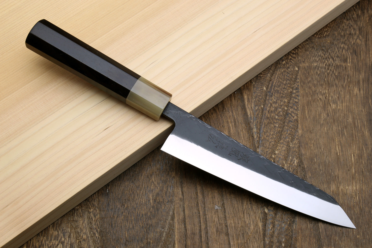 Petty-utility knife with dark handle, light bolster, and textured dark blade
