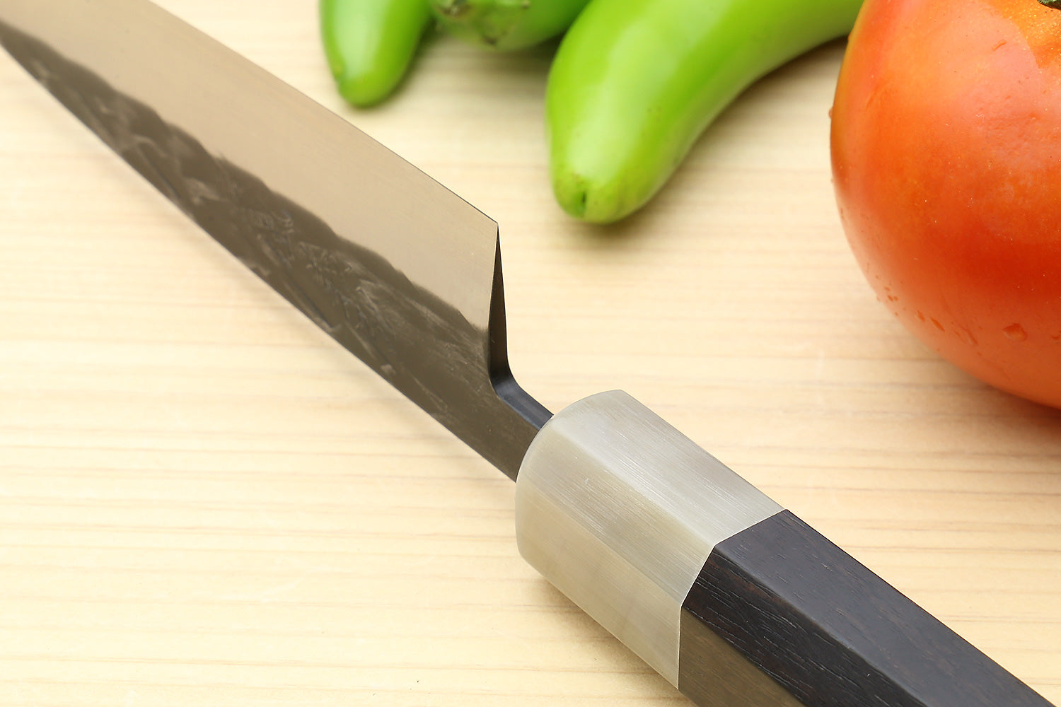 Petty utility knife close-up of gray patterned blade and silver bolster