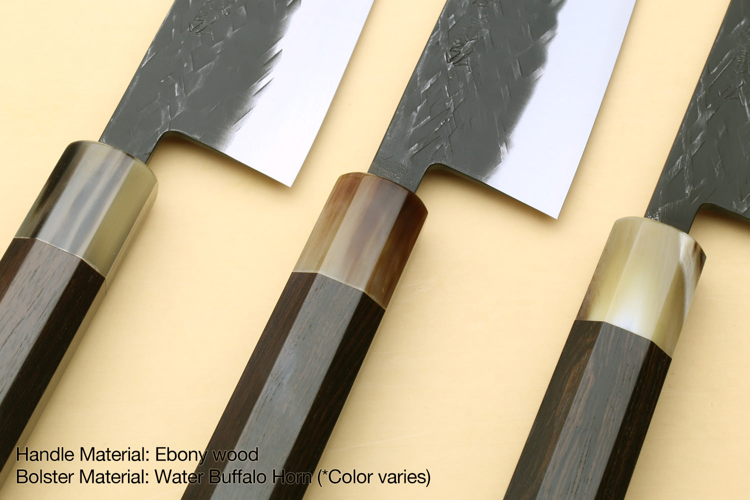 Pair of knives with ebony-wood handles, dark horn bolster, and textured blades