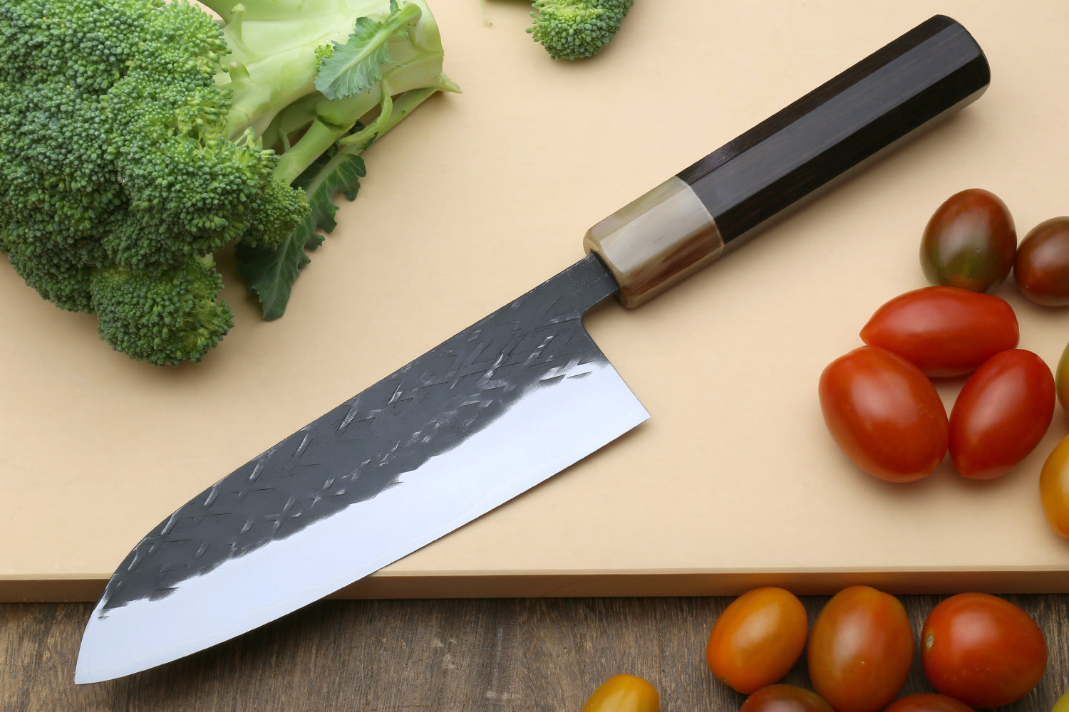 Santoku and petty knives with textured blades and dark wood handles