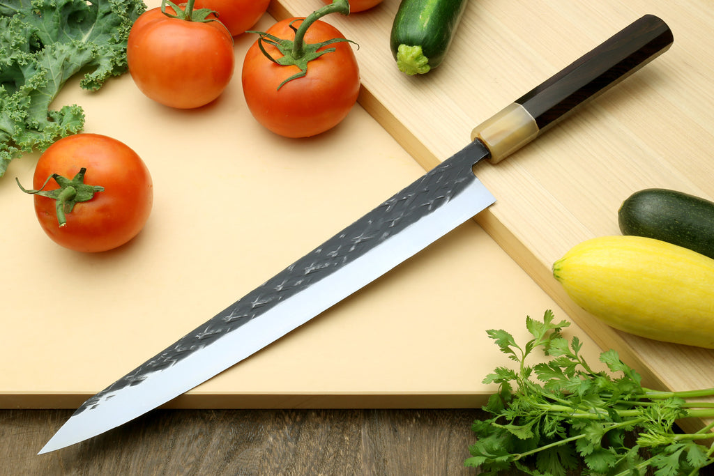 Stainless sujihiki slicer knife with dark patterned blade and brass-toned guard