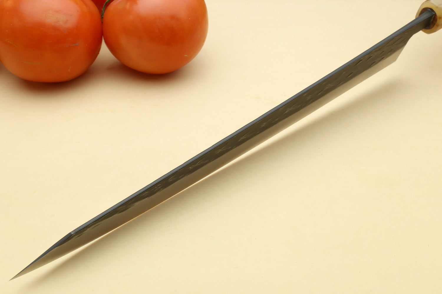 Sujihiki slicer knife with dark patterned blade and dark handle with light ferrule