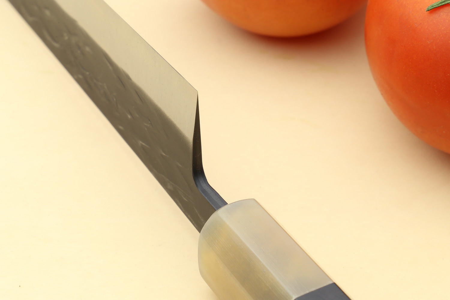 Sujihiki slicer knife with dark patterned blade and translucent-toned handle ferrule