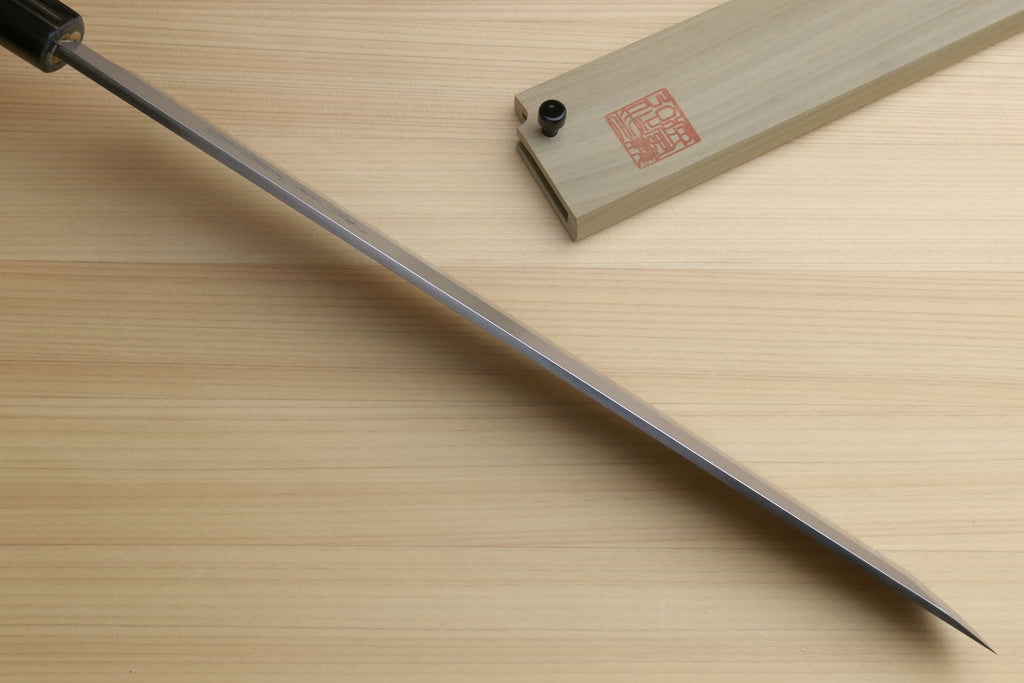 Japanese sushi sashimi knife showing long pointed white steel blade and shitan handle