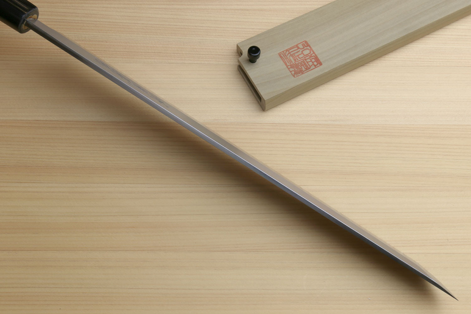 Japanese sushi sashimi knife showing long pointed white steel blade and shitan handle