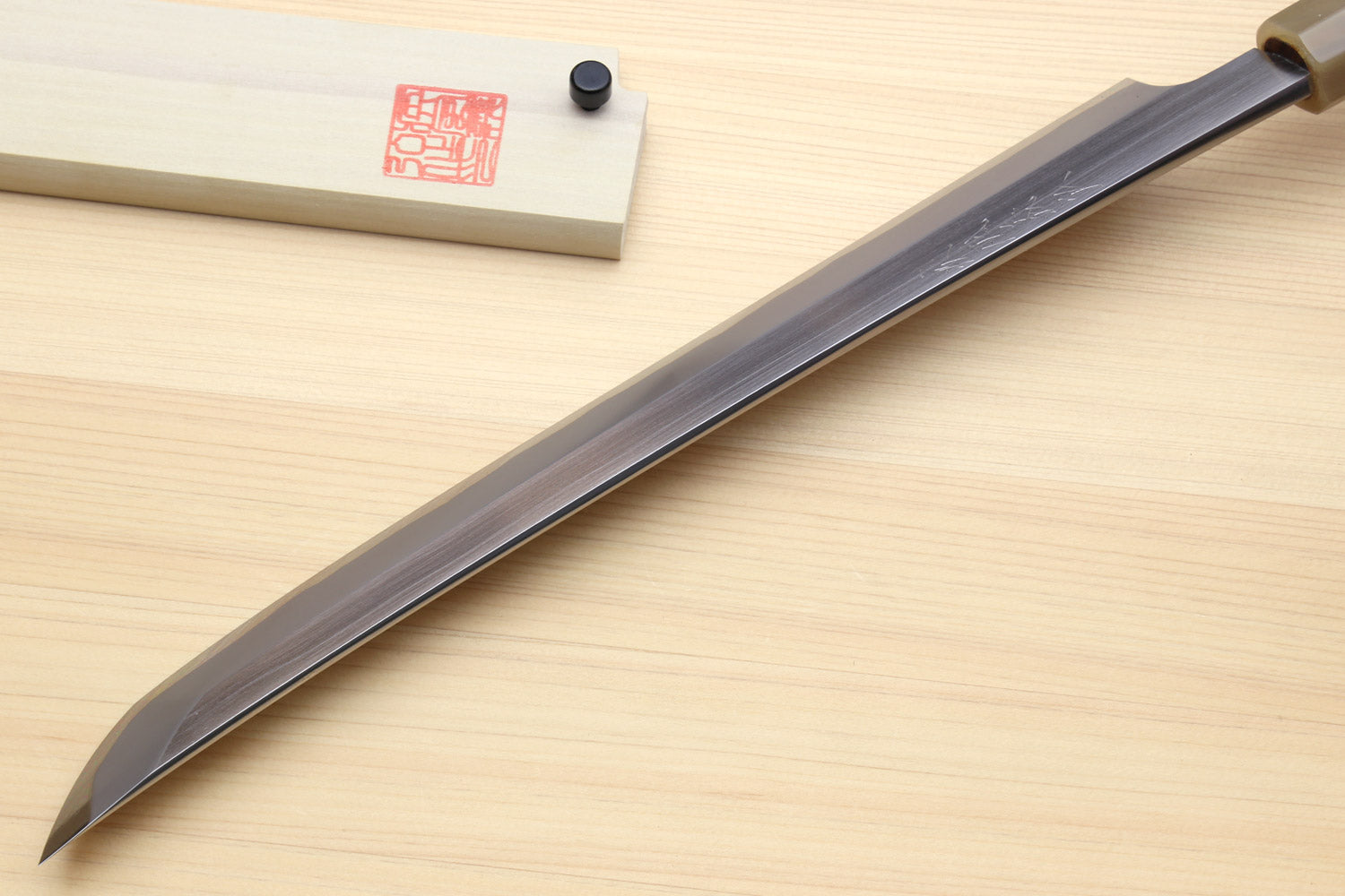 Sushi sashimi knife with long curved dark-finished blade and narrow sakimaru tip