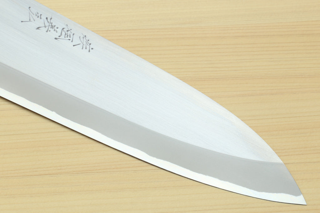 Deba knife close-up of white steel blade with etched text near the spine