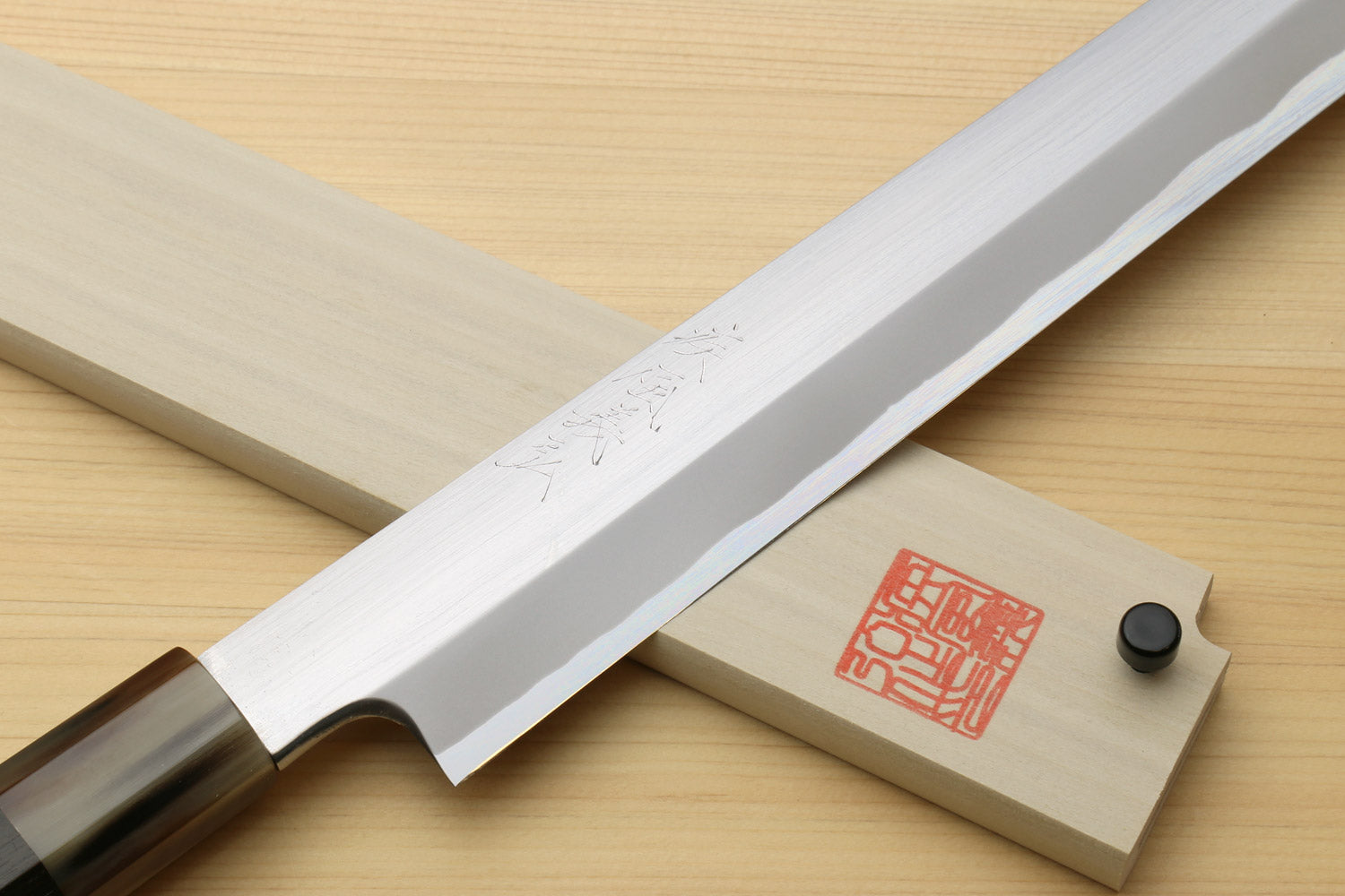 Sashimi sushi knife showing white steel blade profile with wooden saya and red seal