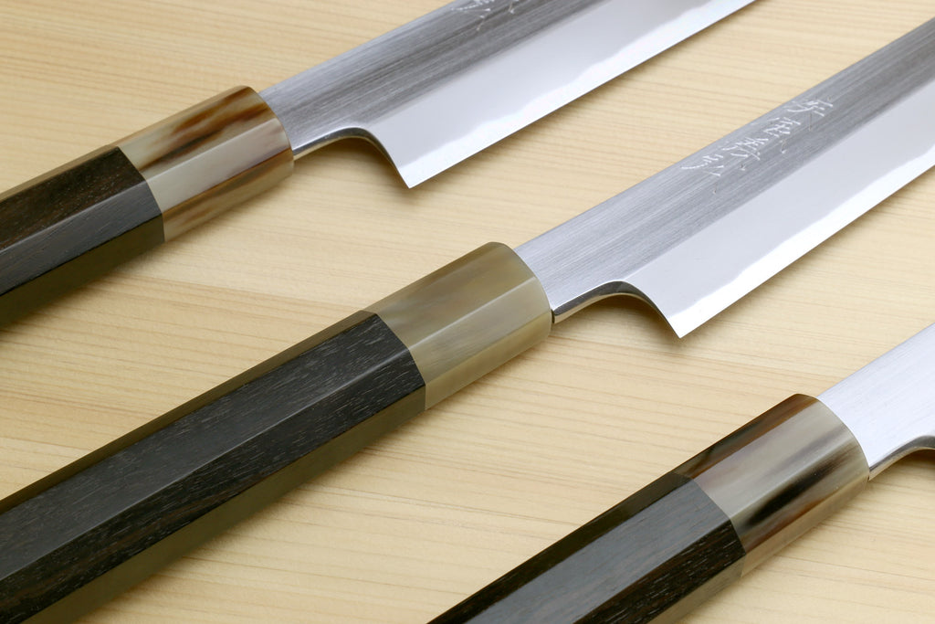 Sashimi sushi knives with contrasting handles, showing white steel blades and edges