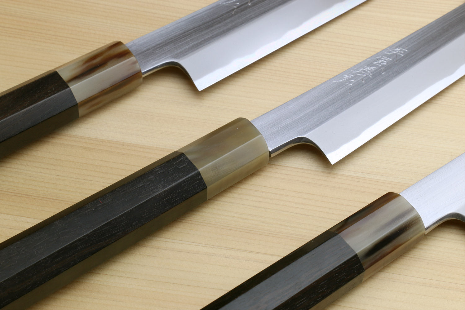 Yanagi-kiritsuke sushi knife with white steel blade and ebony handle, angled view