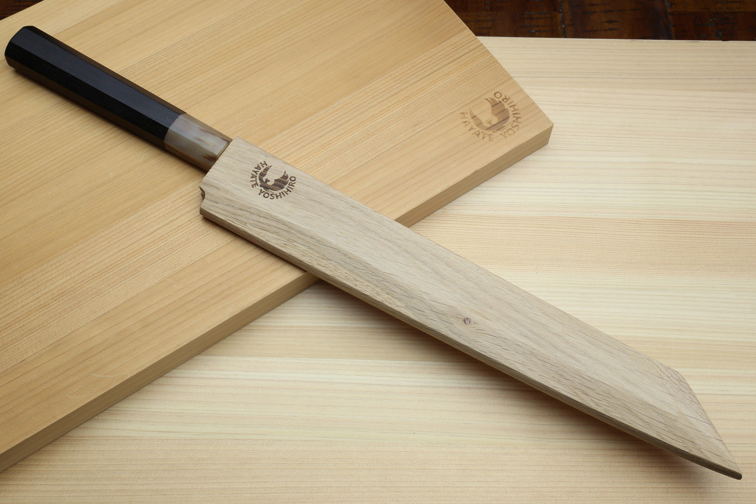 Yanagi-kiritsuke sushi knife with dark bolster, white blade, and light wood handle