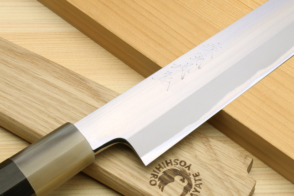 Yanagiba knife angled view with silver blade and dark wooden handle