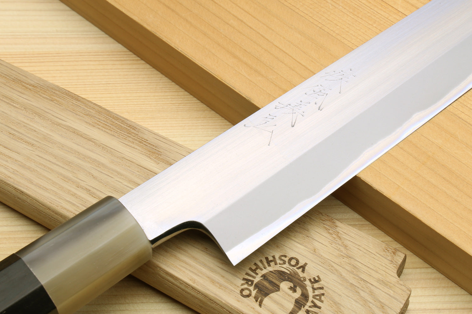 Yanagiba knife angled view with silver blade and dark wooden handle
