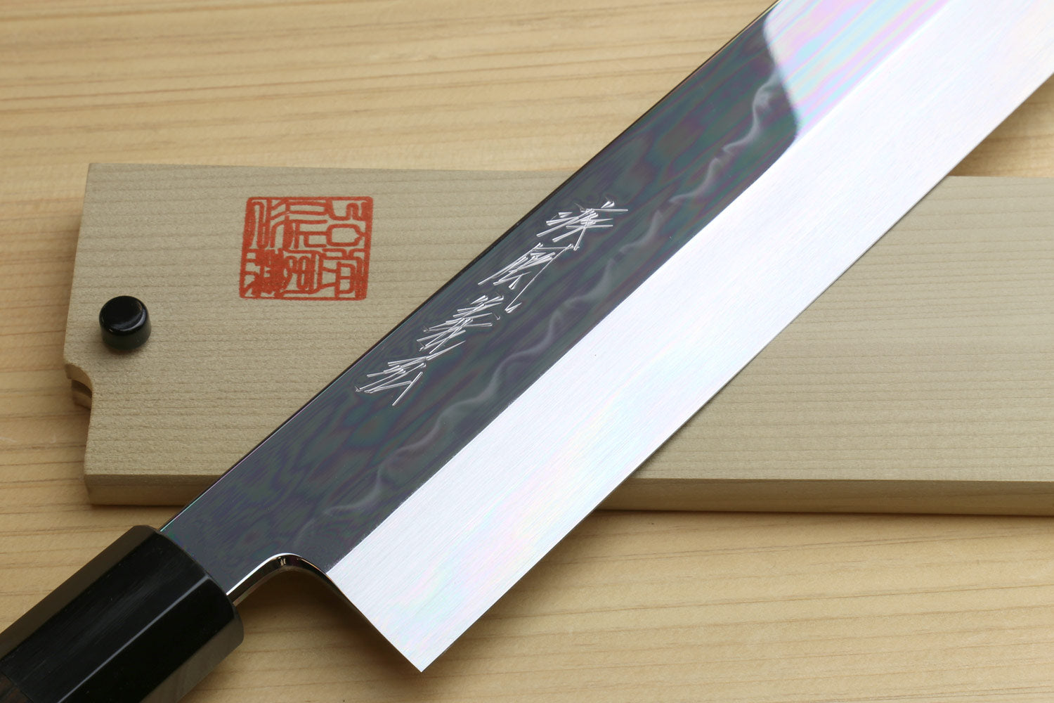 Japanese vegetable knife close-up: white mirror-polished blade with engraved text
