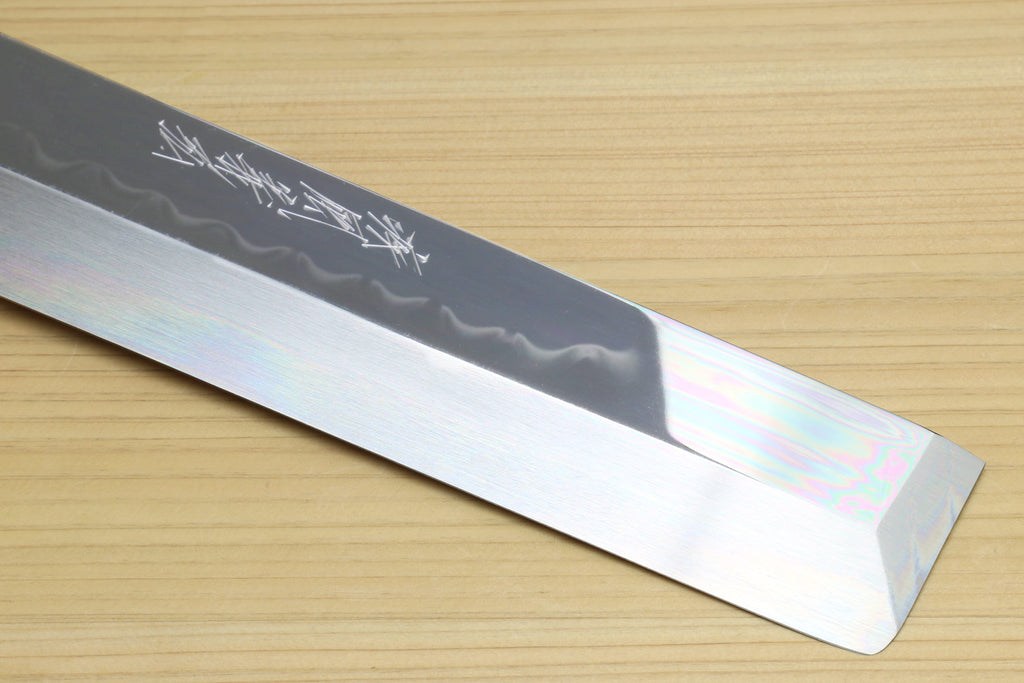 Japanese vegetable knife blade close-up showing mirror finish and engraved markings