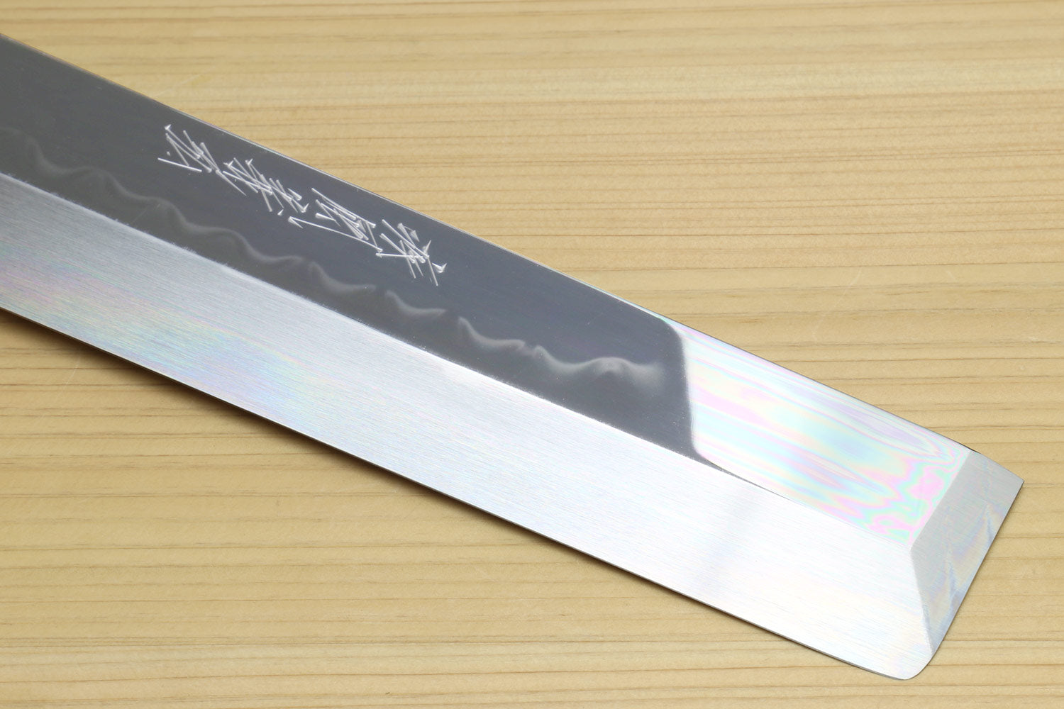 Japanese vegetable knife blade close-up showing mirror finish and engraved markings