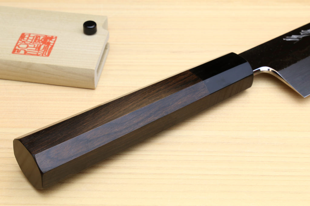 Japanese vegetable knife handle and heel detail with dark ebony grip on wood