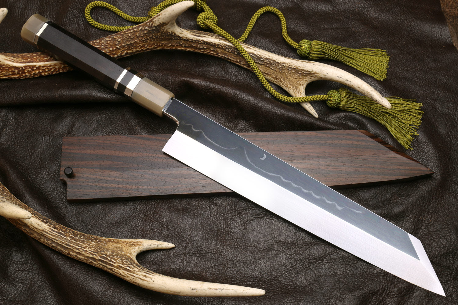 Mirror-polished kiritsuke chef knife with dark handle and saya, metal accents