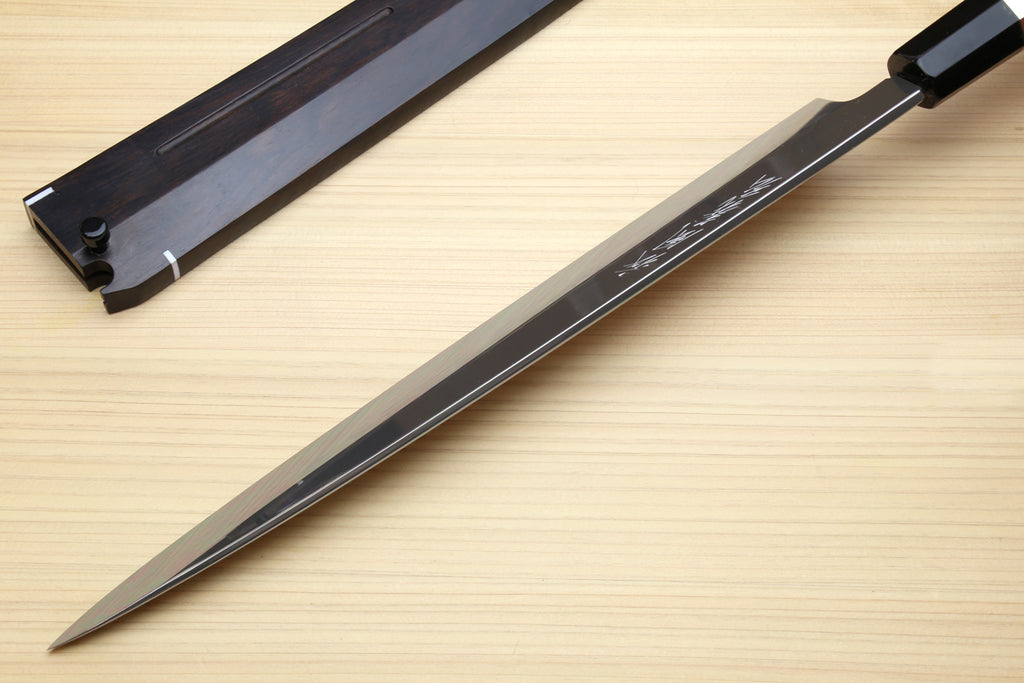 Mirror-finished steel knife with etched text and dark handle, full-length view.