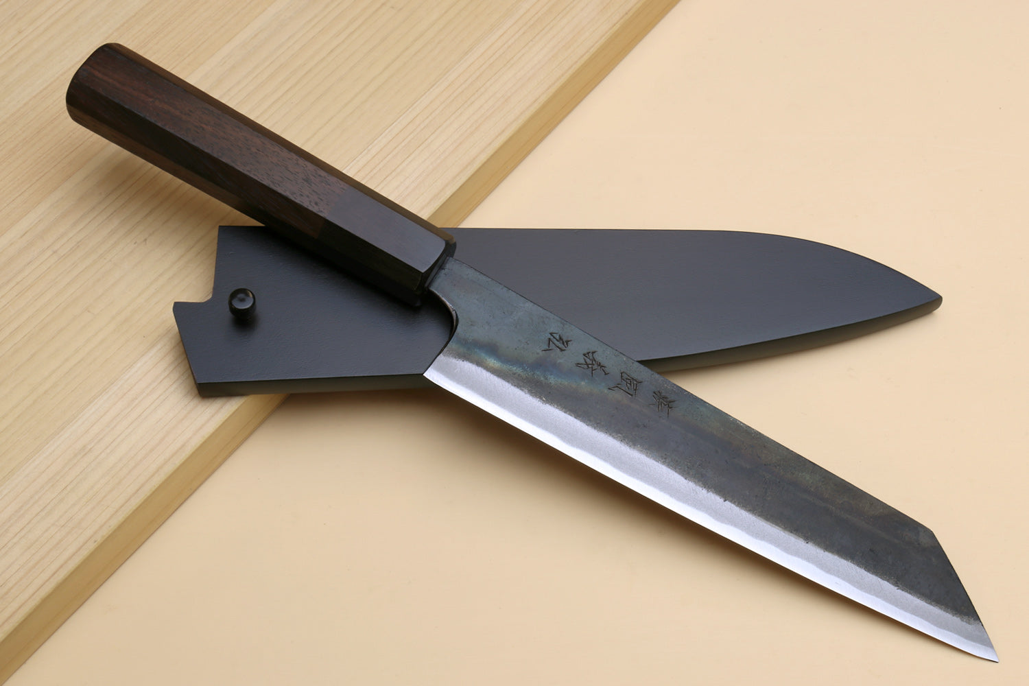 Japanese utility kiritsuke knife with saya cover, dark wooden handle, and visible blade edge
