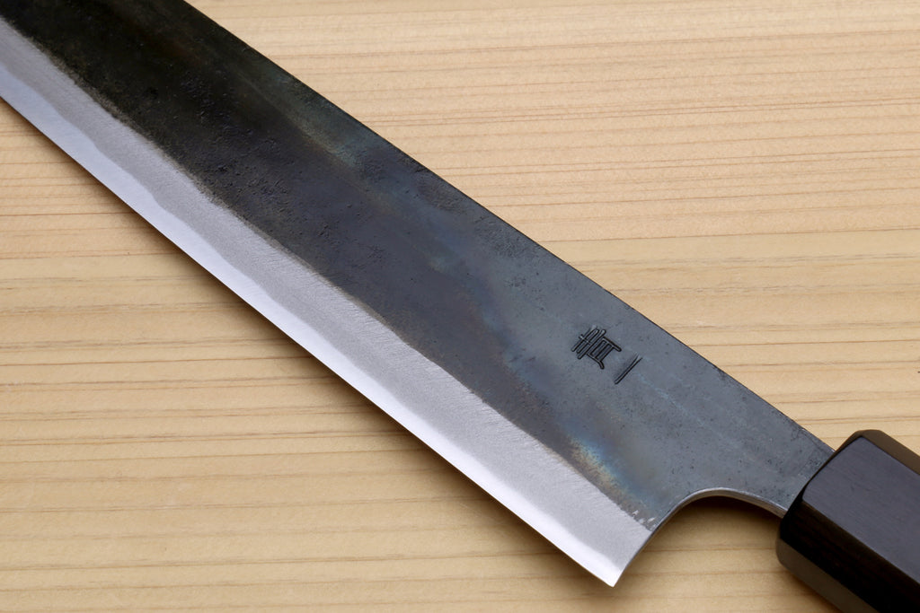 Japanese utility kiritsuke knife close-up of curved blade and blade edge, dark handle