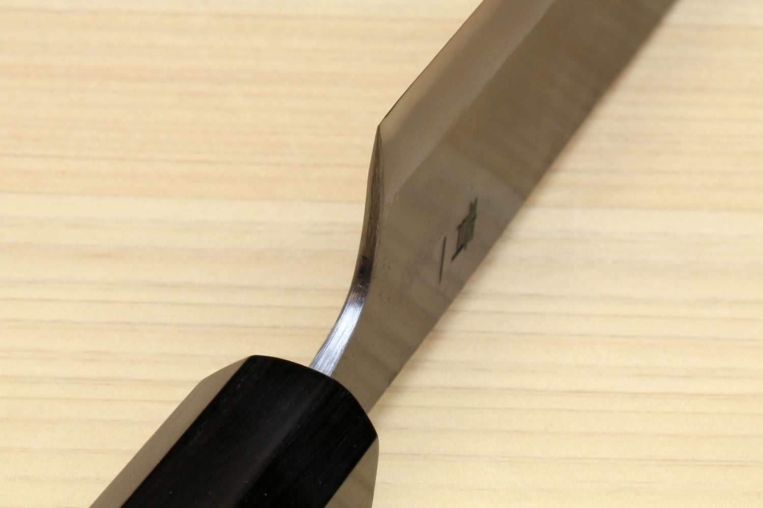 Japanese utility kiritsuke knife side view with dark wooden handle and steel blade