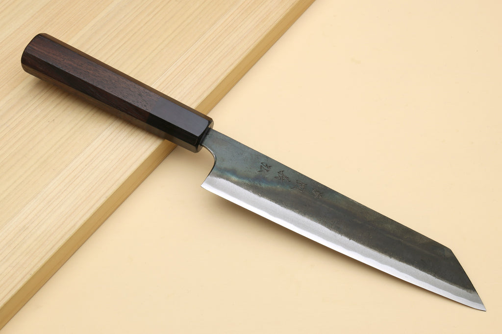 Japanese utility kiritsuke knife with dark wooden handle and kurouchi-finished steel blade