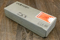 Natural whetstone block with printed markings and orange label on pale side