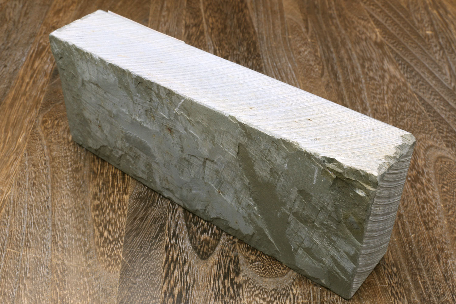 Natural whetstone finishing stone, gray rectangular block with ridged side faces