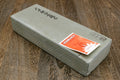 Sharpening whetstone with white face, dark sides, and orange sticker on top