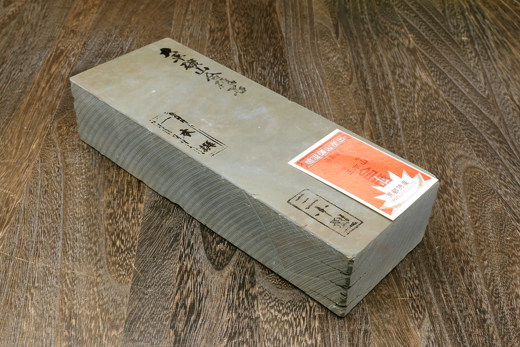 Natural whetstone block with orange label and calligraphy text on top face
