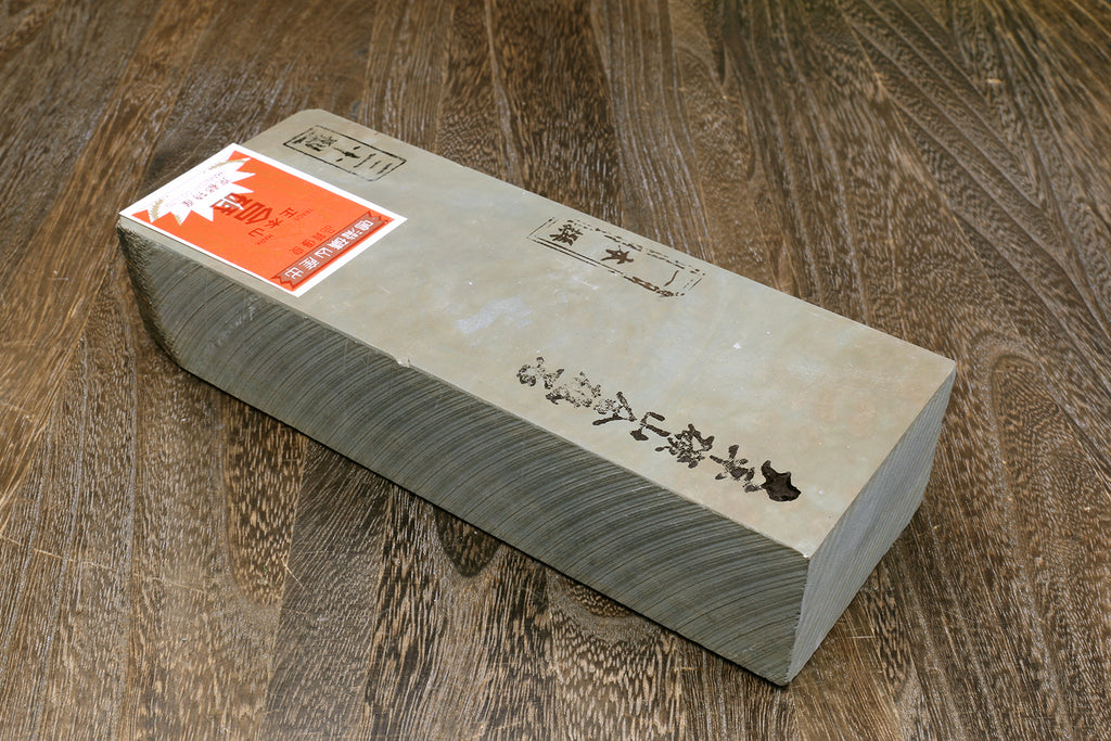 Natural whetstone block with paper label and orange sticker on light side