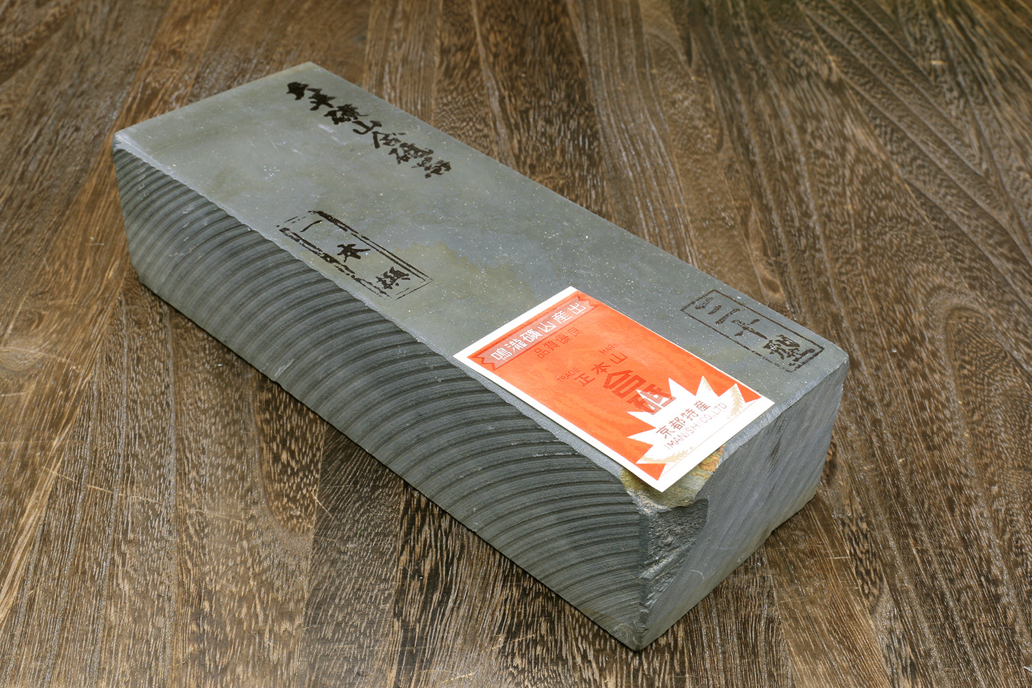 Gray rectangular sharpening whetstone with paper label on top