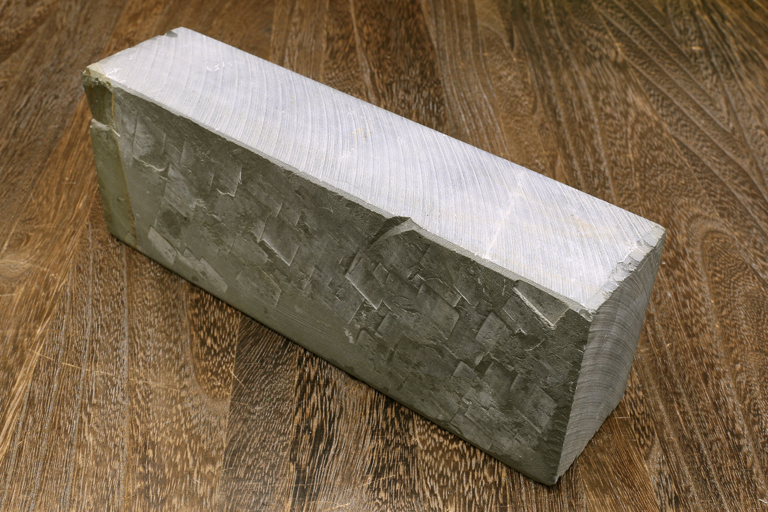 Gray sharpening whetstone with exposed pale top edge and side texture