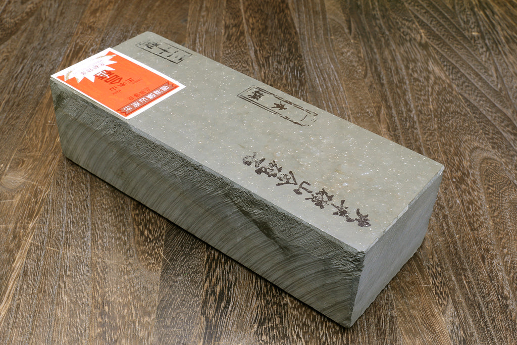 Natural sharpening whetstone block with orange label and engraved markings