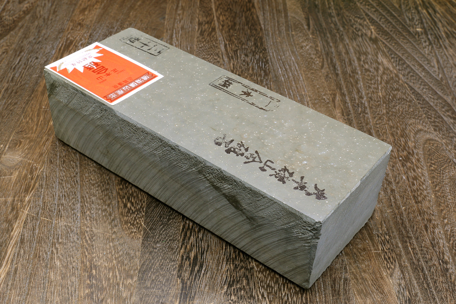Natural sharpening whetstone block with orange label and engraved markings