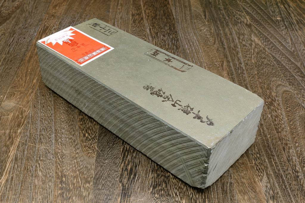 Natural sharpening whetstone, rectangular gray-green stone block with printed labels