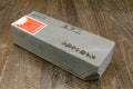 Natural sharpening whetstone with printed label on white surface, gray sides