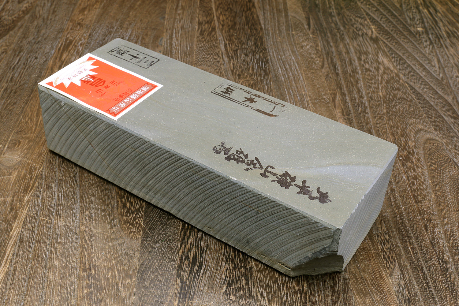 Natural sharpening whetstone with printed label on white surface, gray sides