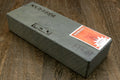 Natural whetstone block with printed label and orange sticker on pale top