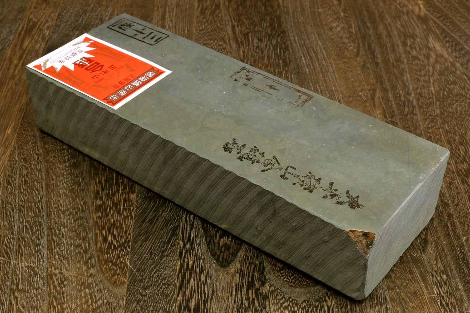 Natural sharpening whetstone block, green-gray with orange label on side