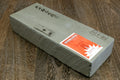 Natural sharpening whetstone, rectangular block with label on one end.